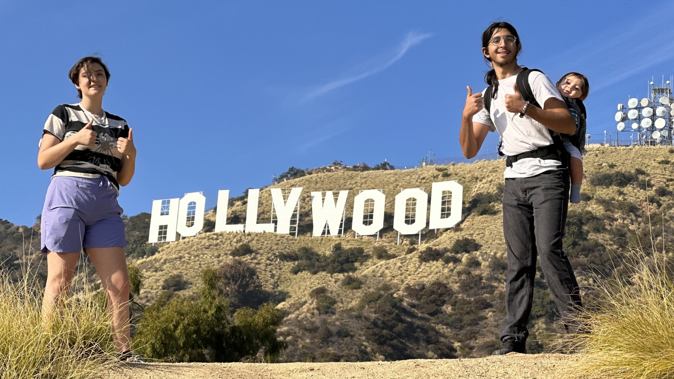 A family poses in front of the Hollywood Sign on the Hollywood Sign Tour