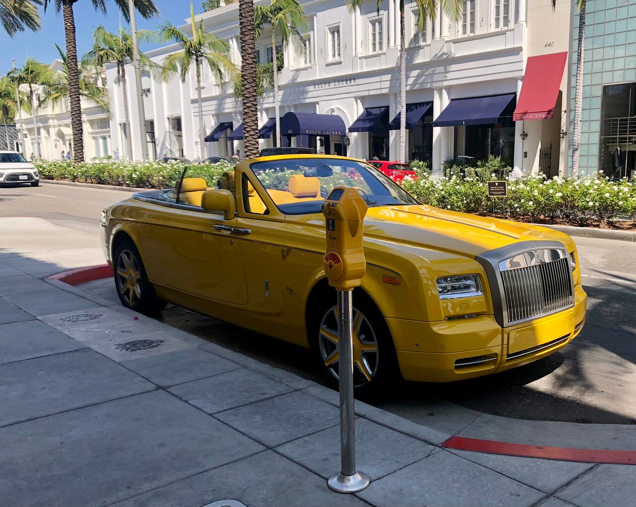 A yellow rolls royce on rodeo drive on the beverly hills tour