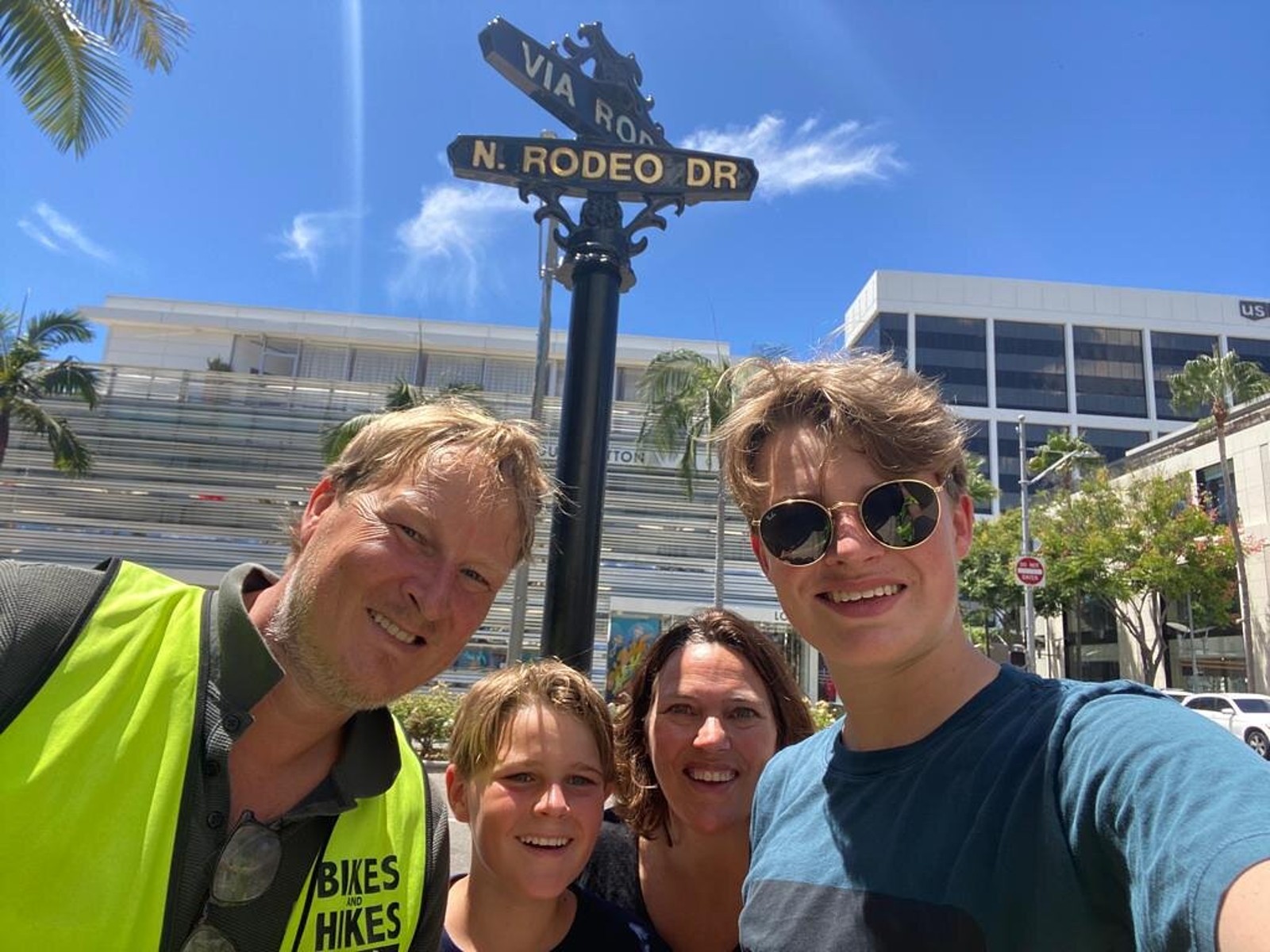 Guests pose with the Rodeo Dr. sign on the Beverly Hills Tour
