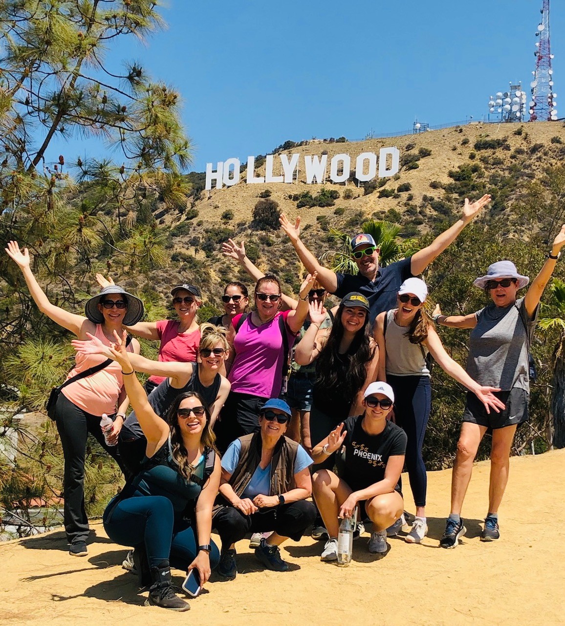 A group poses in front of the Hollywood Sign on the Hollywood sign tour with Bikes and Hikes LA