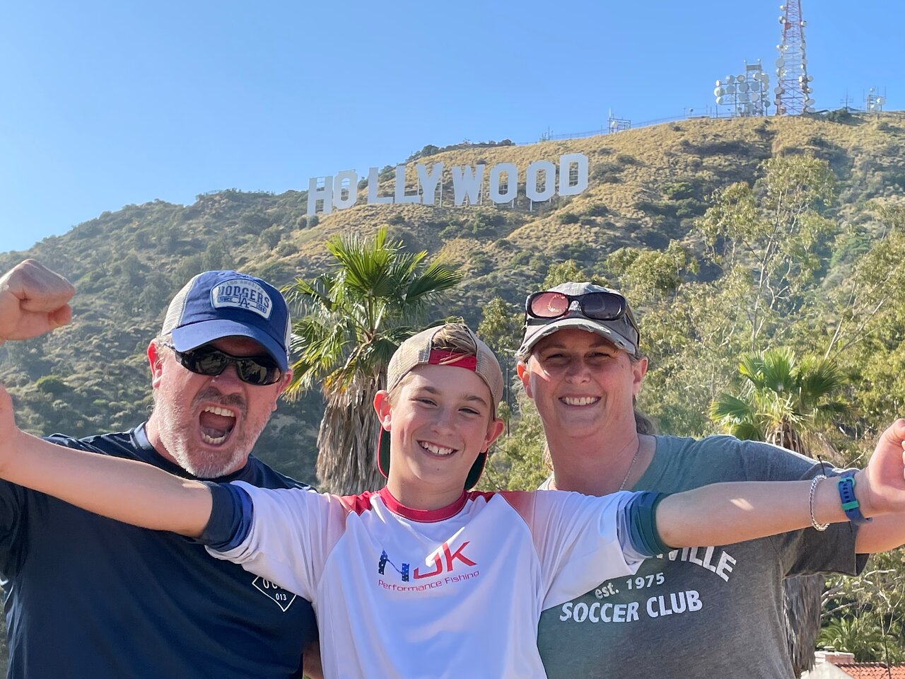 A family poses in front of the Hollywood Sign on the Hollywood Sign Tour