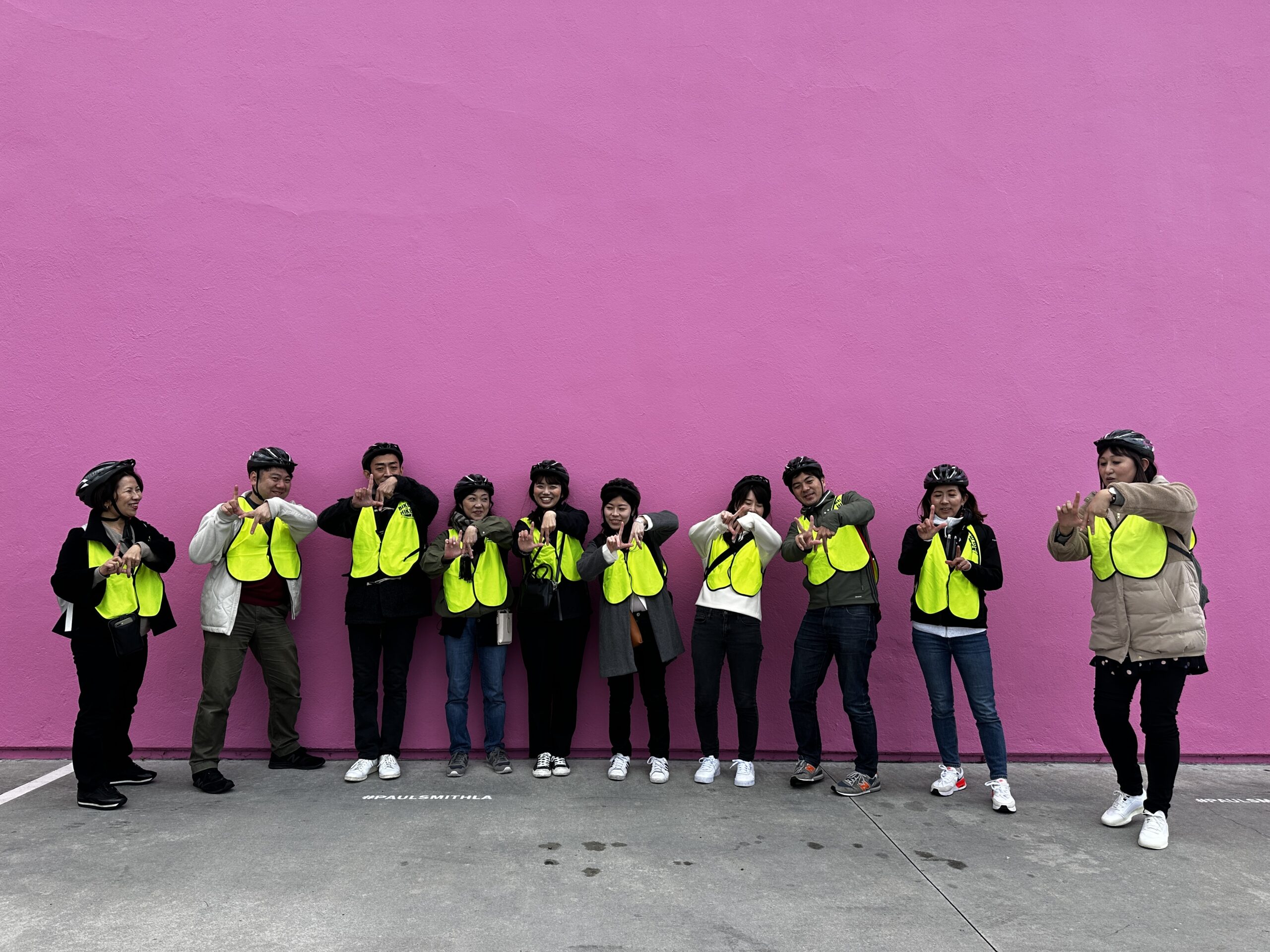 Guests on our Beverly Hills Tour take a photo with the iconic pink wall