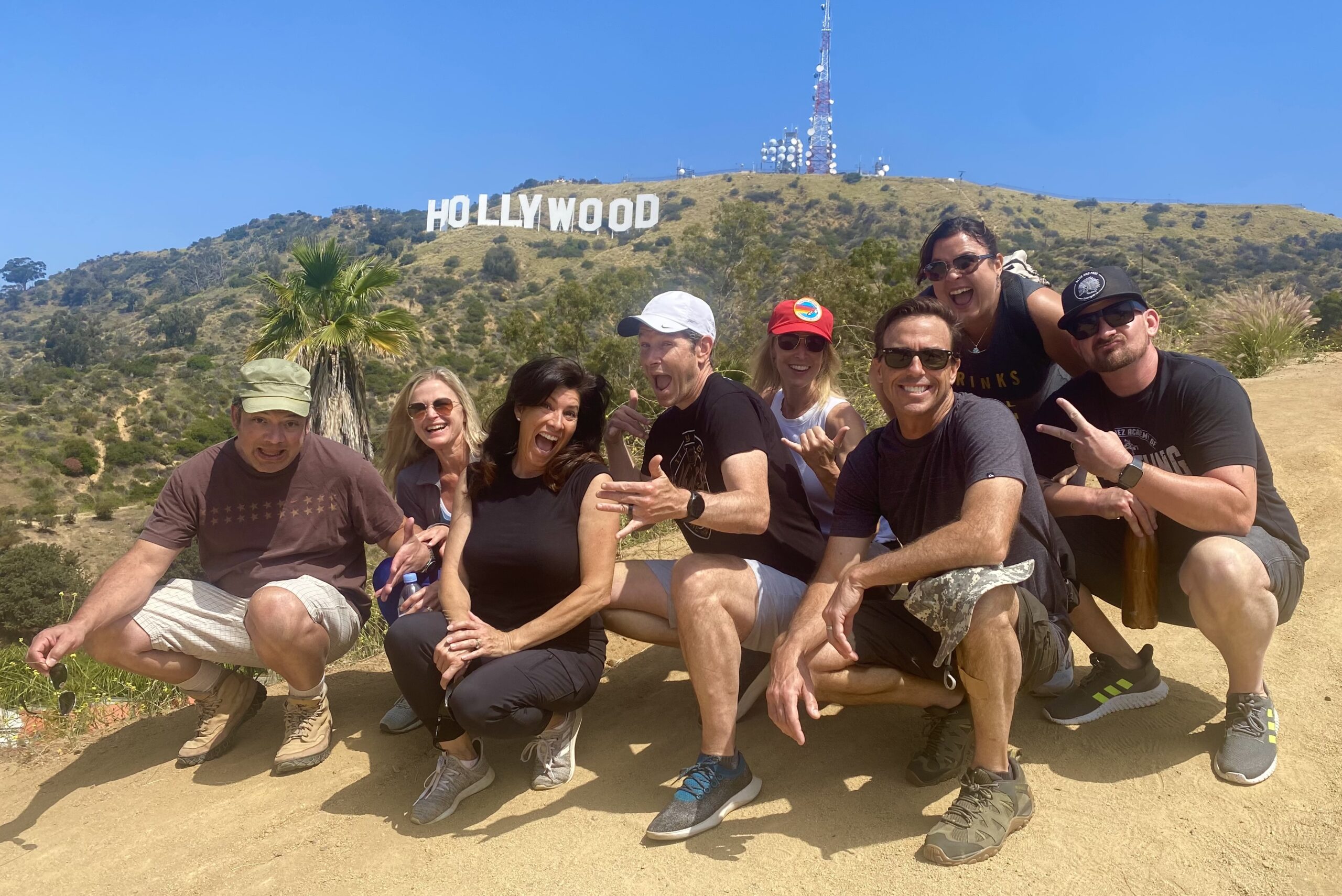 Group smiles in front of the Hollywood Sign on the Hollywood Sign Hike