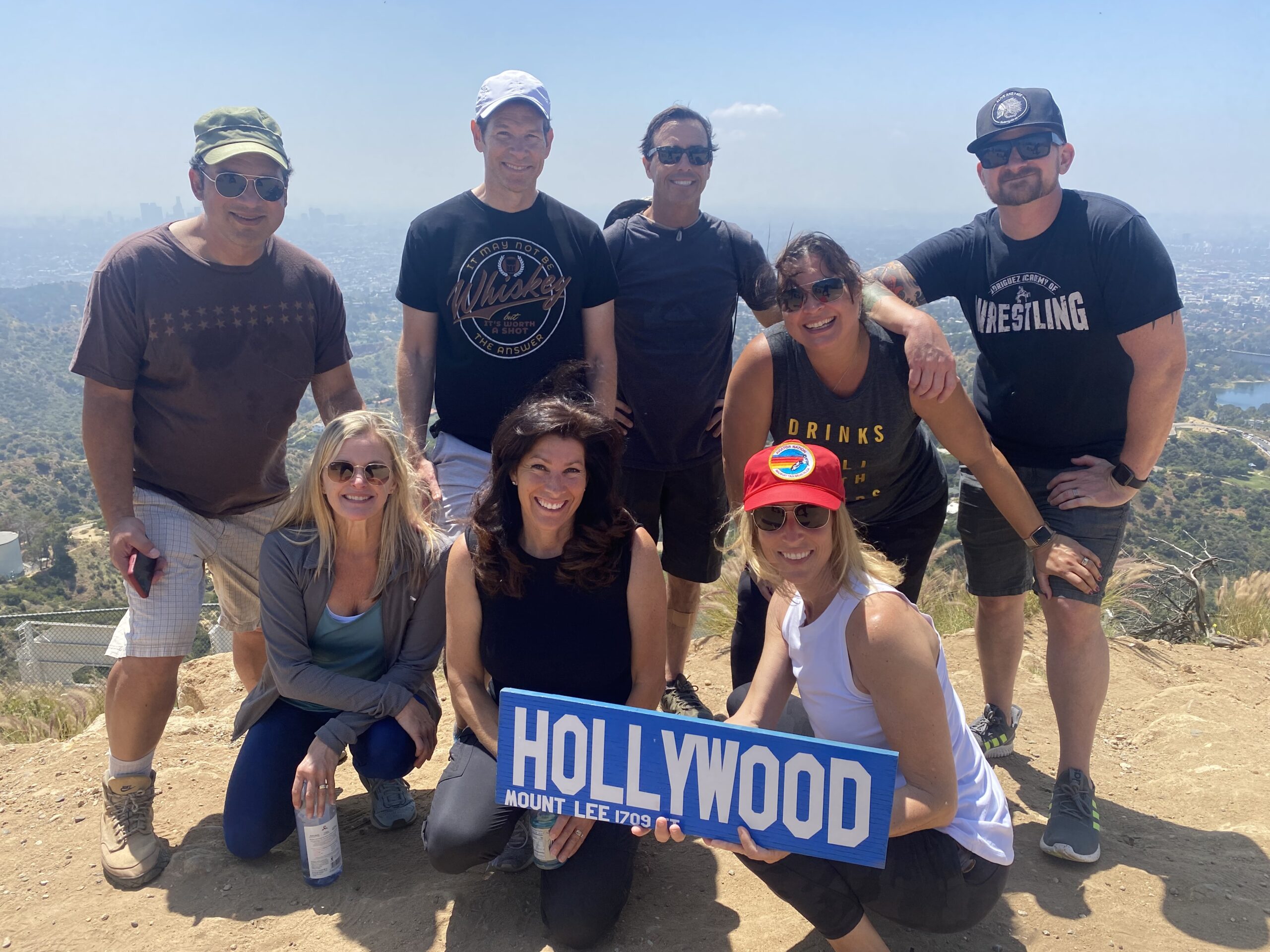 A group makes it to the top of the Hollywood Sign Hike with a Hollywood Plaque